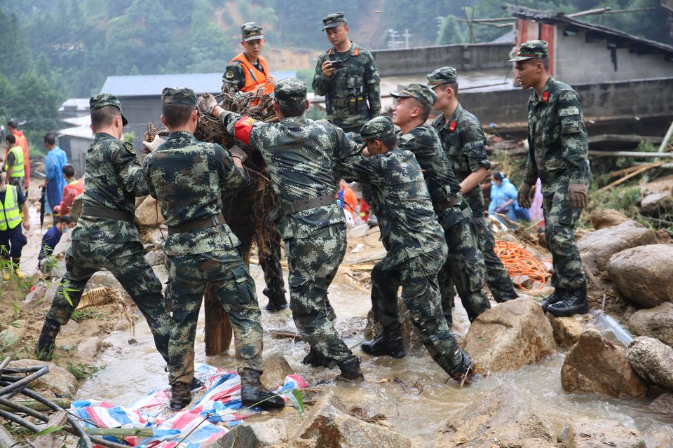 Nhân viên cứu hộ Trung Quốc tại hiện trường một ngôi nhà bị sập do lũ cuốn (ảnh: Reuters)