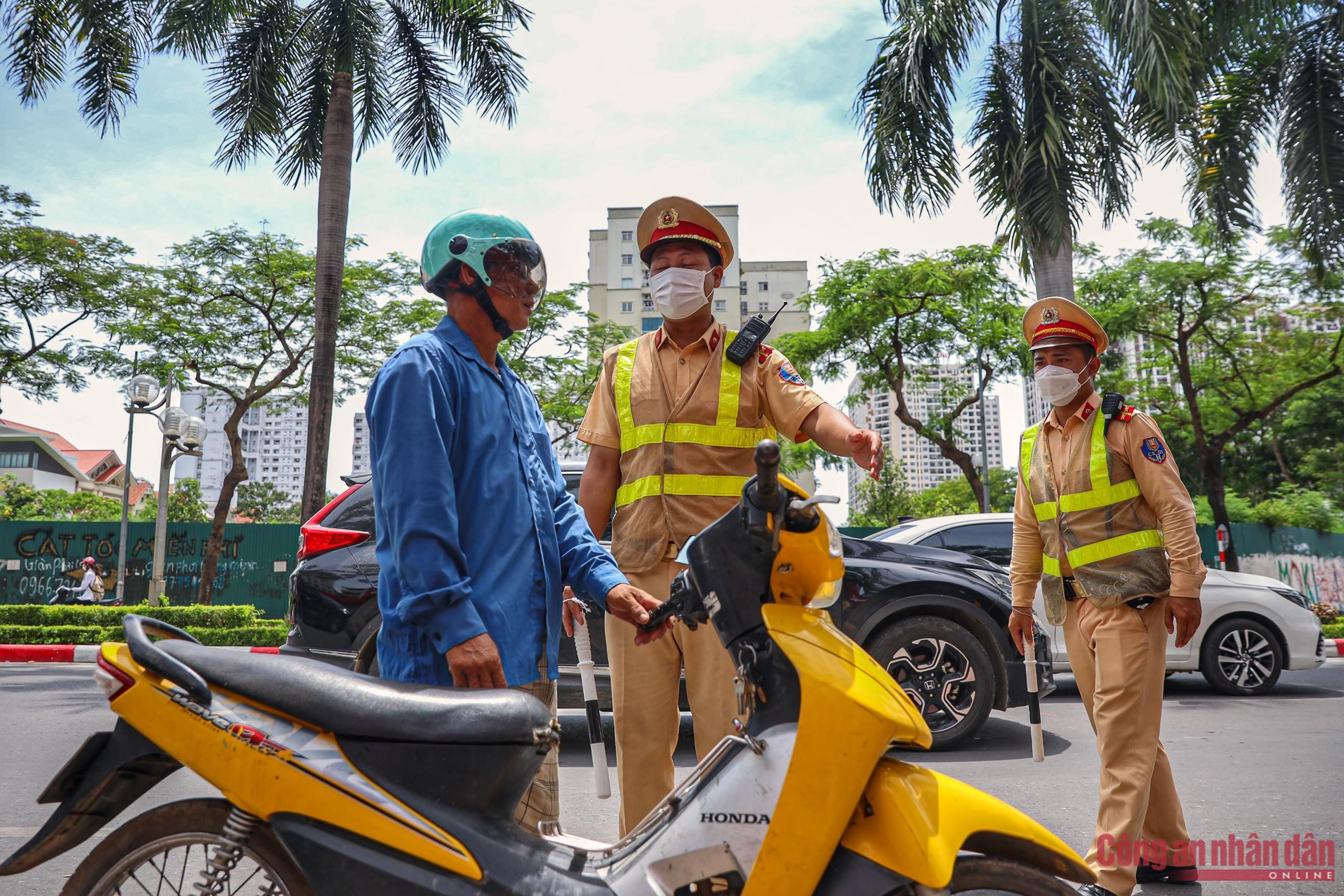 Chiến sĩ CSGT làm nhiệm vụ điều tiết giao thông, xử lý vi phạm tại khu vực đường Lê Đức Thọ.&nbsp;Lúc này người tham gia giao thông ai cũng muốn nhanh chóng về nhà trốn nóng.