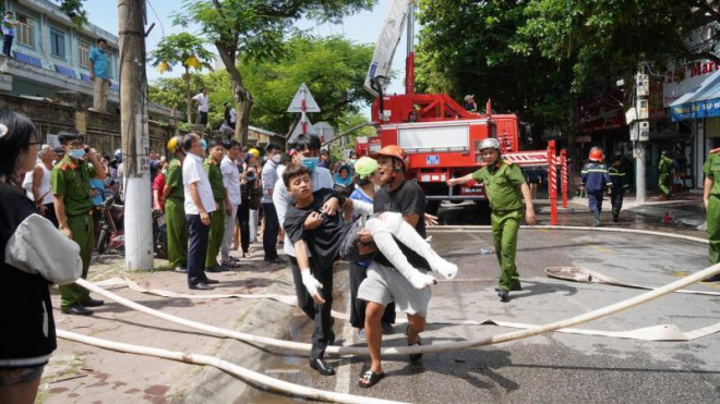 Một cháu trai bị thương được cứu thoát ra ngoài, đưa đi cấp cứu.