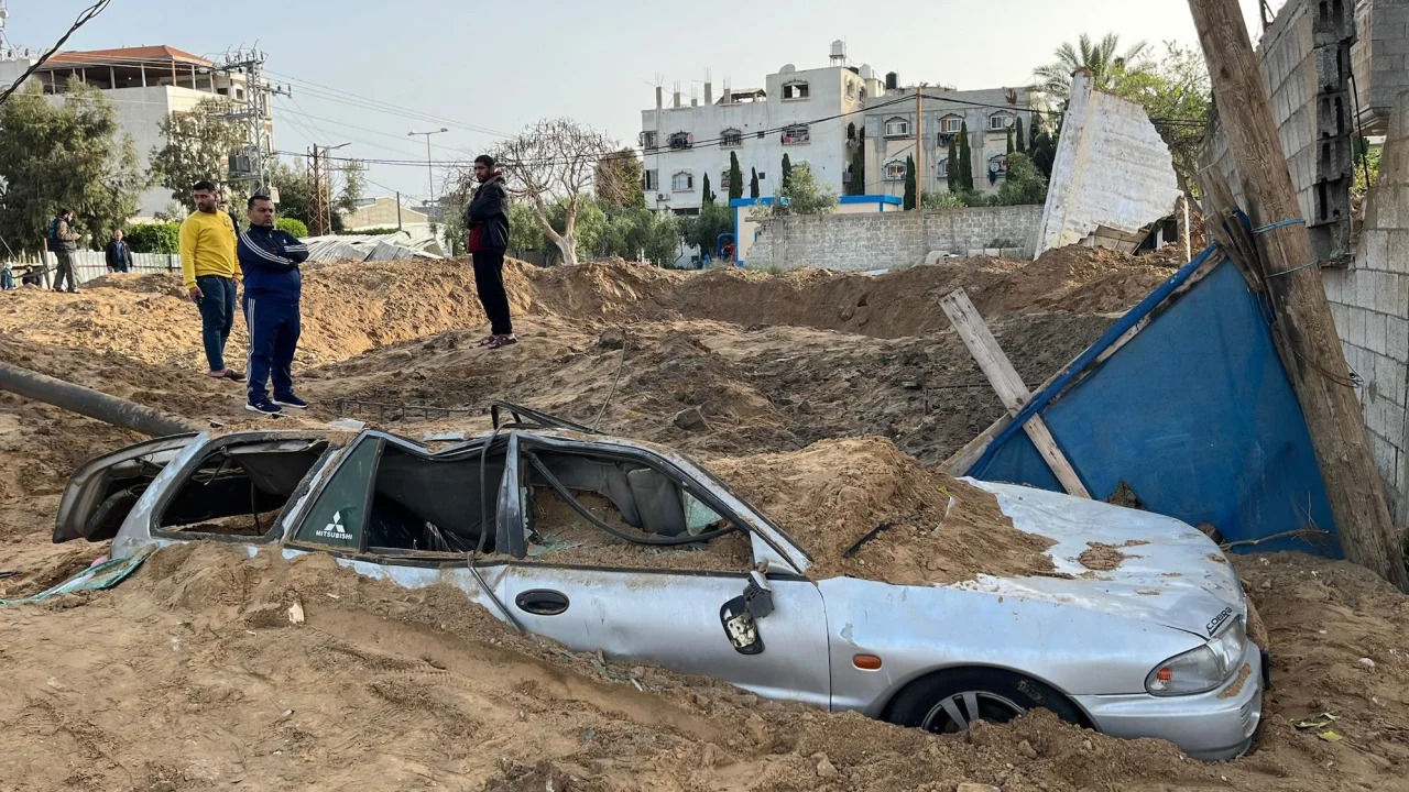 Một chiếc ô tô ở dải Gaza bị chôn vùi trong hố đạn rocket (ảnh: CNN)