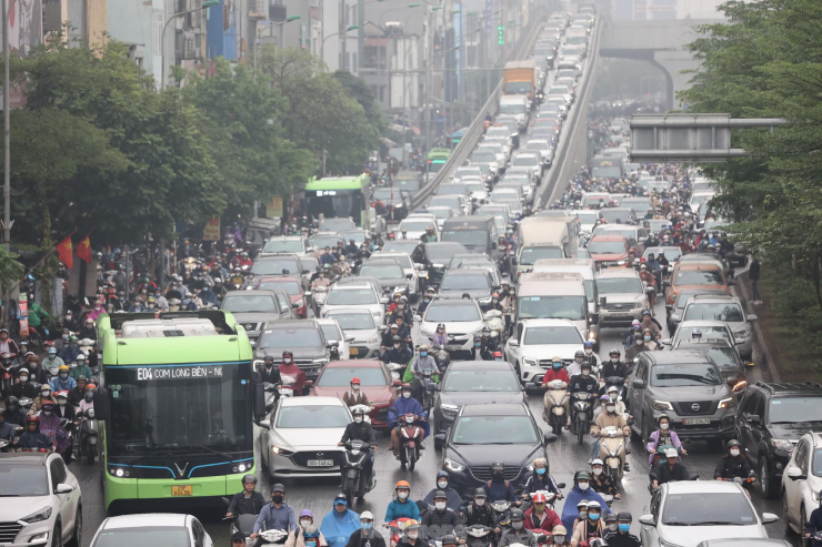 Nút giao Ngã Tư Sở với đường Vành đai 2 cũng ùn ứ kéo dài. Xe máy, ô tô chen nhau hỗn loạn suốt dọc tuyến đường.