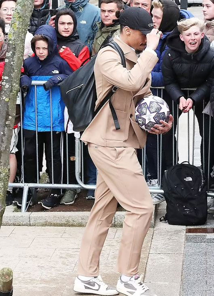 Sane lên xe bus cùng toàn đội Bayern Munich khi đội mũ và lấy tay che vết sưng ở môi sau khi lĩnh cú đấm của Mane