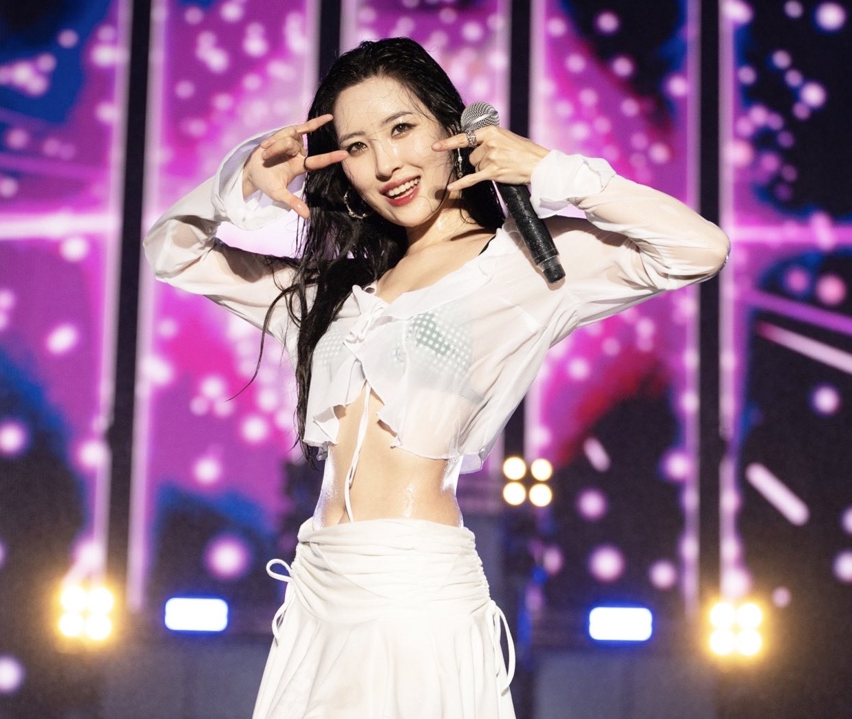 Sunmi&nbsp;mặc áo sơ mi dài tay dáng croptop cùng chân váy trắng, bên trong là nội y màu xanh trông cá tính và&nbsp;gợi cảm.