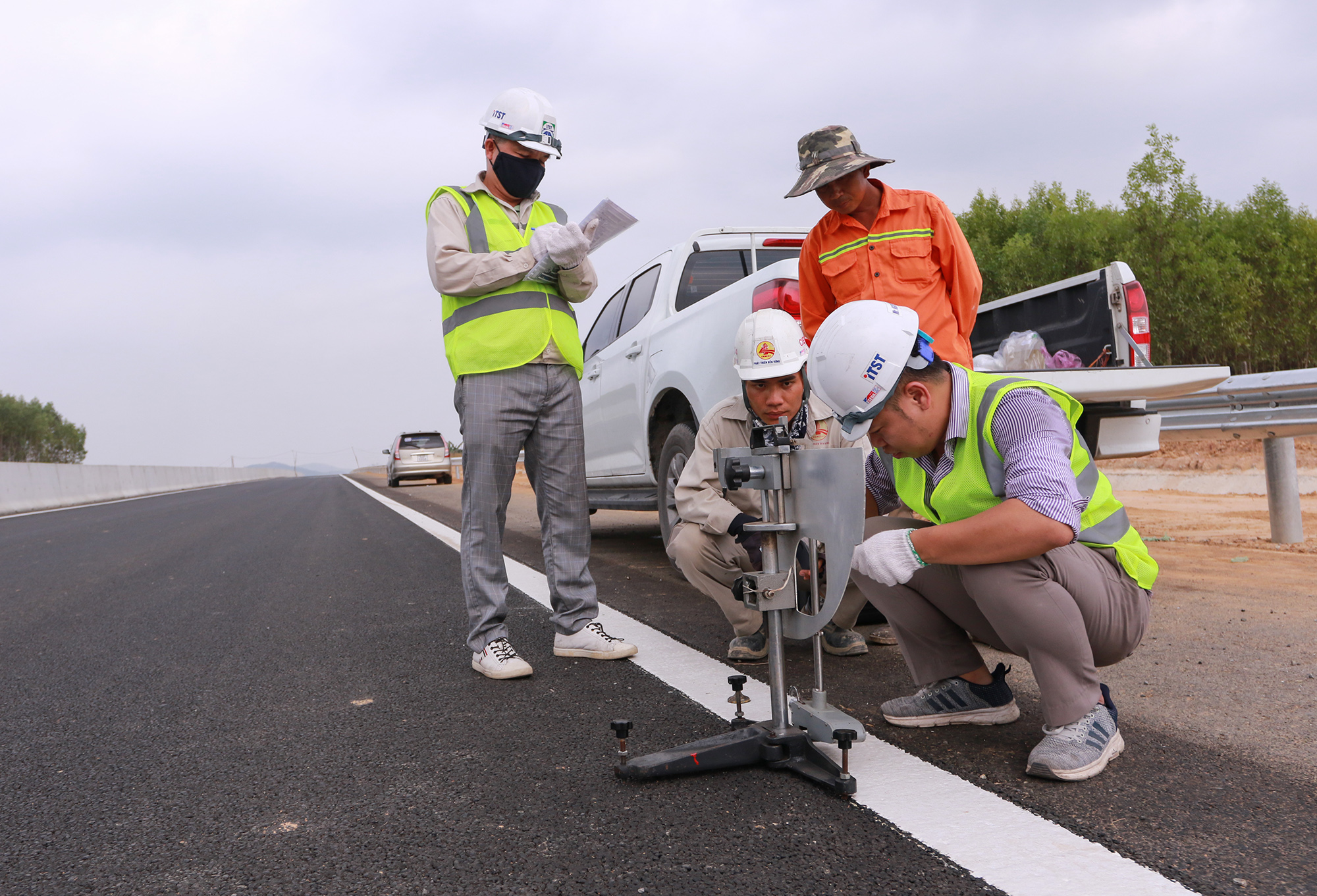 Kỹ sư, công nhân đo độ chính xác của vạch kẻ làn đường. Hiện tại tuyến cao tốc còn nhiều hạng mục phải hoàn thành trước 30/4 như lắp đặt khe co giãn các cầu, biển báo, sơn kẻ đường, dải phân cách…