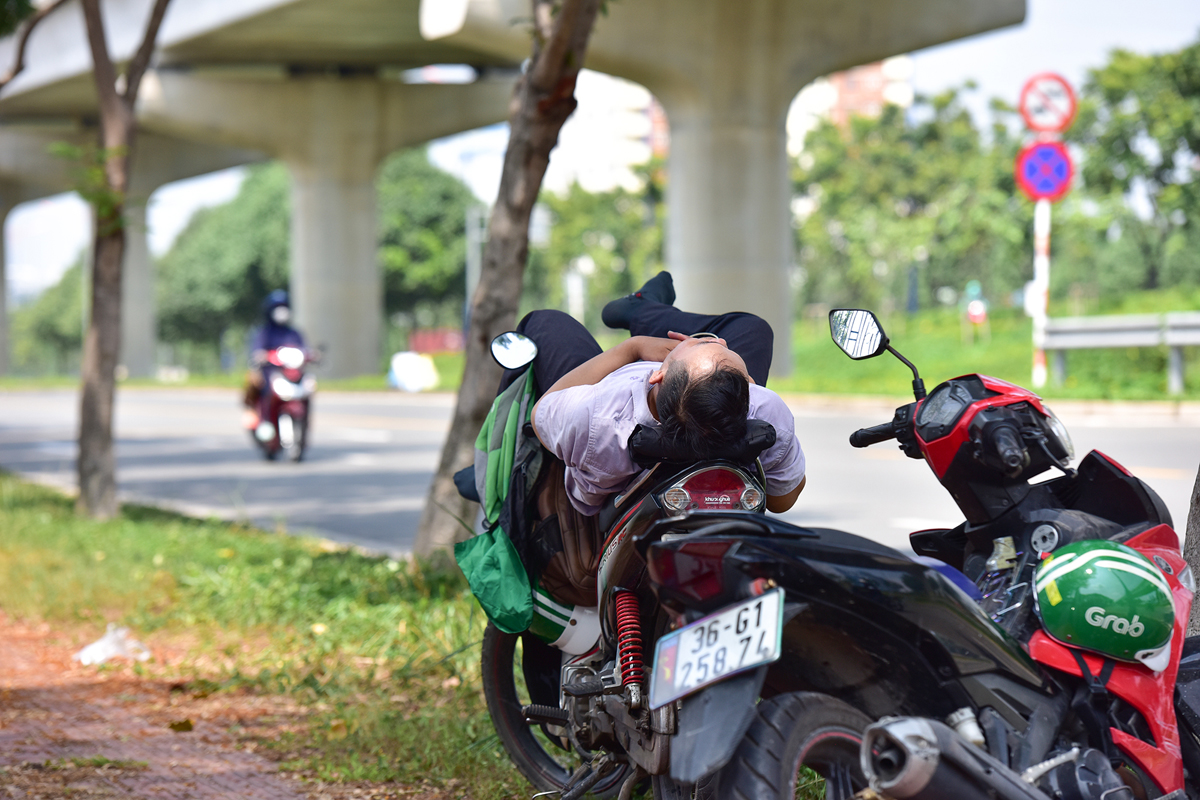 Thời điểm giữa trưa, nhiều lao động ngoài trời tranh thủ tìm đến những khu vực mát mẻ như gầm cầu, bóng cây xanh để nghỉ trưa.