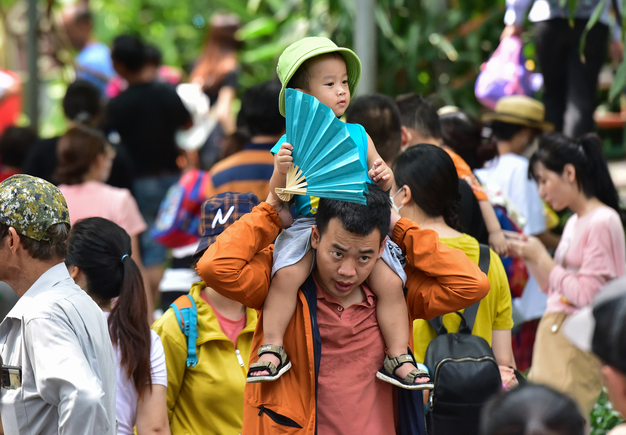 Những gia đình có trẻ nhỏ khá vất vả khi di chuyển giữa dòng người đông đúc. Nhiều trẻ được người lớn bế, cõng để di chuyển tham quan các khu vực.