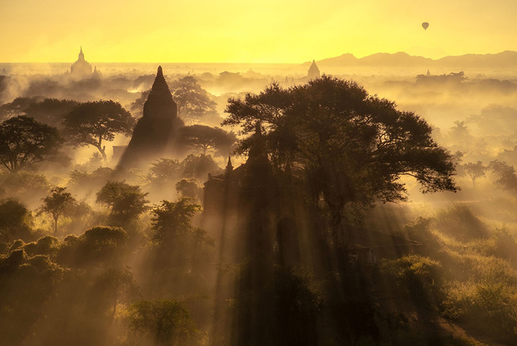 Những tia sáng chiếu xuyên qua những tán cây và ngôi chùa ở Bagan.
