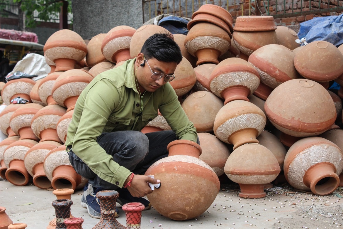   Manoj Kumar, một người bán nồi đất sét, đang gắn vòi vào nồi. Ở Ấn Độ, nhiều người không có tiền mua tủ lạnh đã chọn trữ nước trong nồi đất. Nồi đất giữ nước mát lâu  hơn.“Vào mùa hè, tôi làm 2.000 – 3.000 nồi đất để bán”, anh Manoj nói. (ảnh: Aljazeera) 