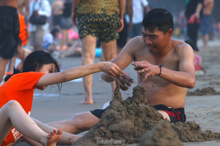 Nhiều ông bố thích thú được chơi cát cùng con ở bãi biển.