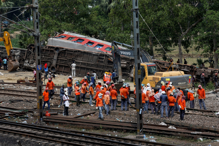 Lực lượng chức năng dọn dẹp hiện trường vào sáng 3-6, sau đêm xảy ra thảm họa đường sắt - Ảnh: REUTERS