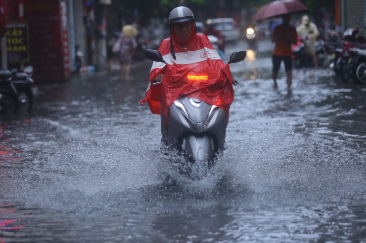 Xe máy "rẽ sóng" khi lao vào biển nước.