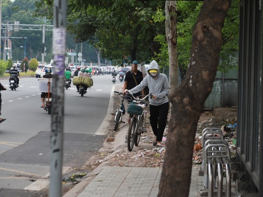 Một số người dẫn bộ xe đạp ngược chiều trên vỉa hè qua chốt kiểm soát của CSGT. Ảnh: Phương Vinh