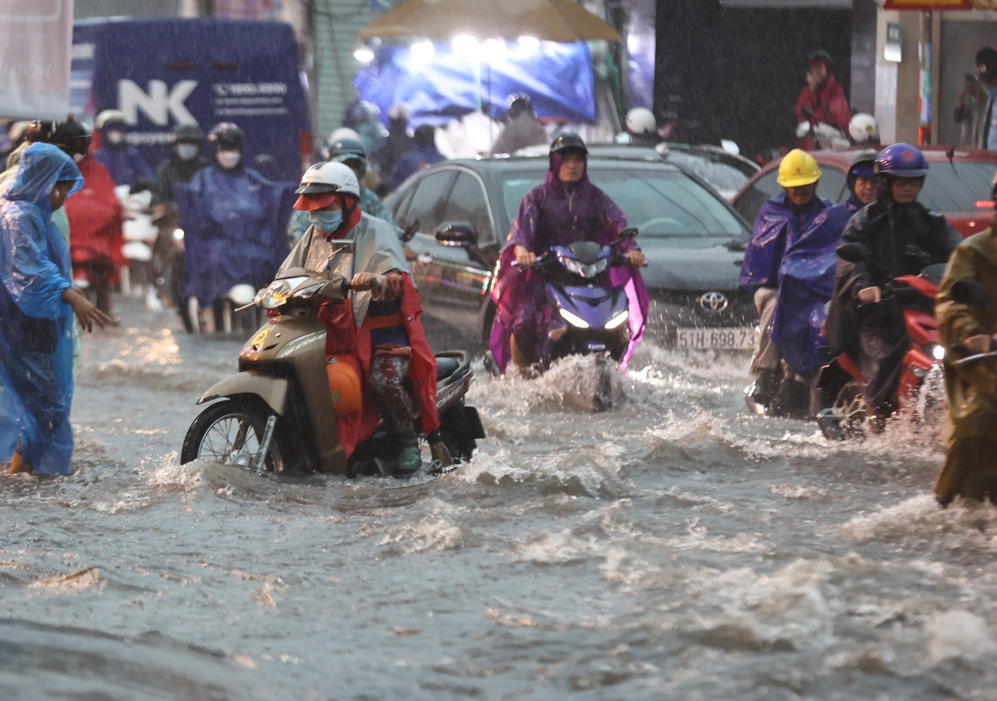 Một số đoạn trũng thấp nước ngập lút bánh xe máy, người dân phải “bơi” về nhà vào giờ cao điểm. Giao thông một số khu vực bị ngập nước, ùn ứ kéo dài.