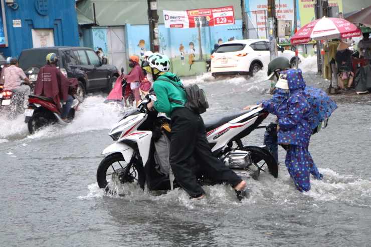 Hai em nhỏ đẩy xe máy giúp mẹ