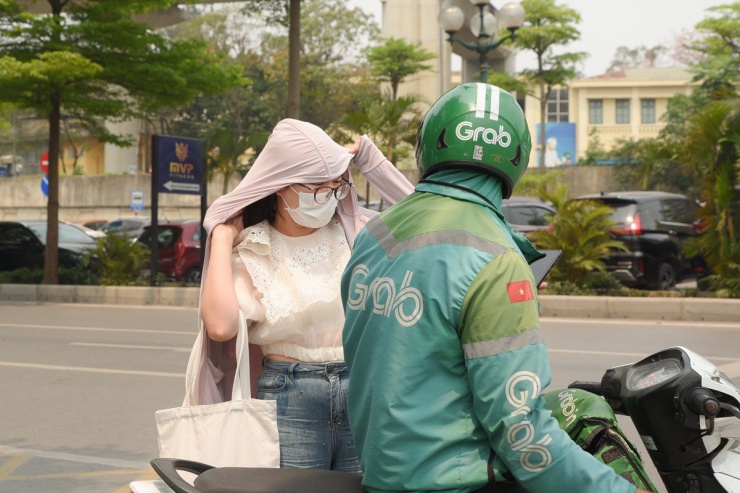 Một người phụ nữ dùng áo chống nắng trùm kín khi ra đường.