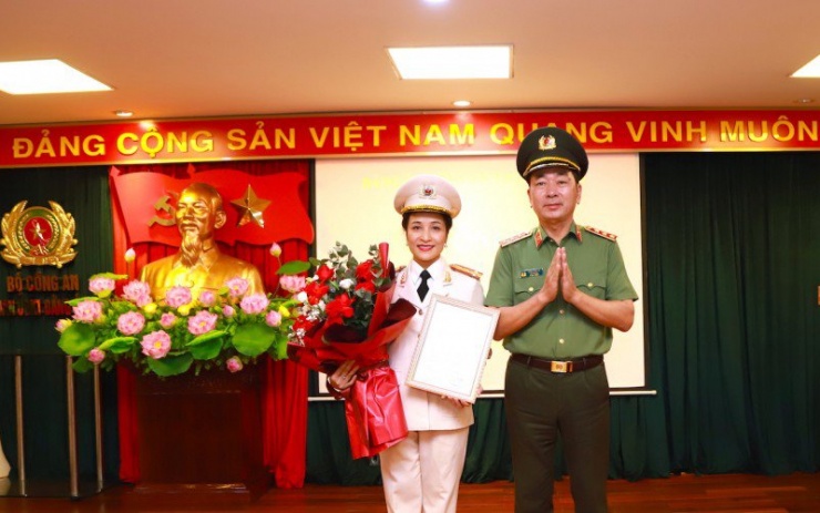 Thứ trưởng Trần Quốc Tỏ trao Quyết định chuẩn y của Ban Bí thư và tặng hoa chúc mừng Đại tá Nguyễn Thuý Quỳnh. Ảnh: CA