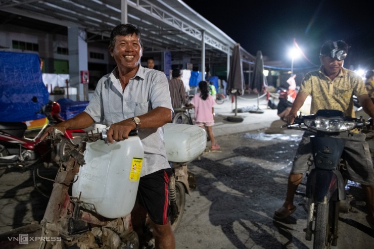 "May có được mấy can nước về dùng, không có cũng không biết phải làm thế nào", anh Phạm Văn Bé (góc trái) ở chợ Rạch Già, xã Tân Phước nói khi nhận được những can nước miễn phí.