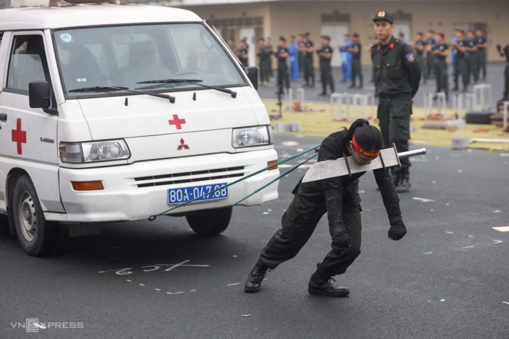 Hạ sĩ Lò Thị Thu Hương dùng dây đeo vào cổ để kéo xe. Nữ chiến sĩ cho biết mất gần 5 tháng để thực hiện thành thục động tác.