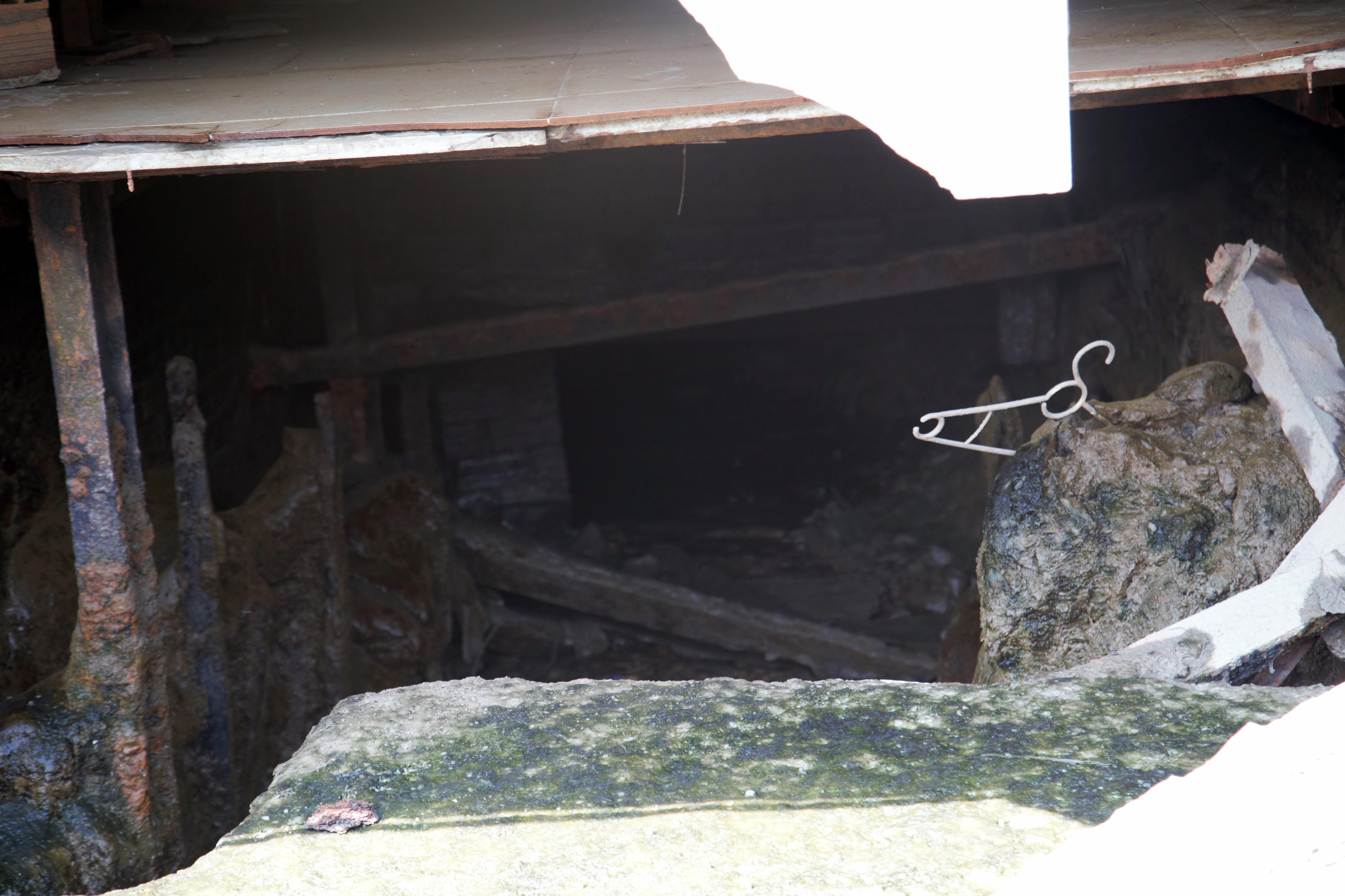 Bên trong khu vực sạt lở, một số căn nhà bị sụt lún nặng, sập tường, xuất hiện nhiều “hàm ếch” lớn.