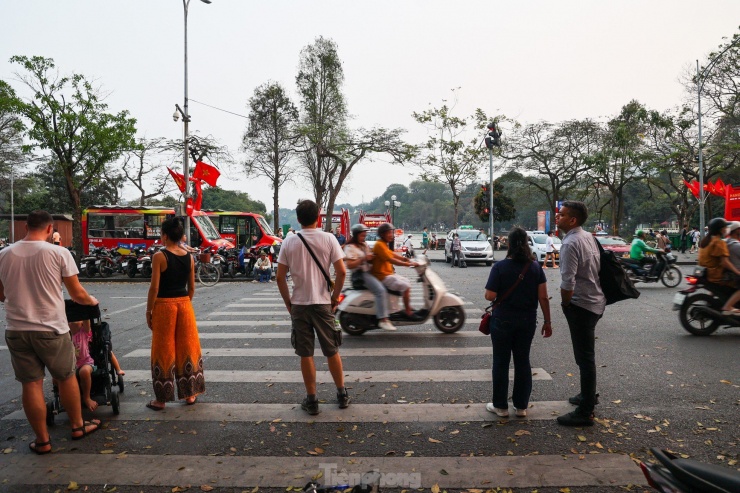 Du khách nước ngoài bối rối, không biết sang đường như thế nào khi trên phố Đinh Tiên Hoàng, quận Hoàn Kiếm, đèn ưu tiên cho người đi bộ bị các phương tiện 