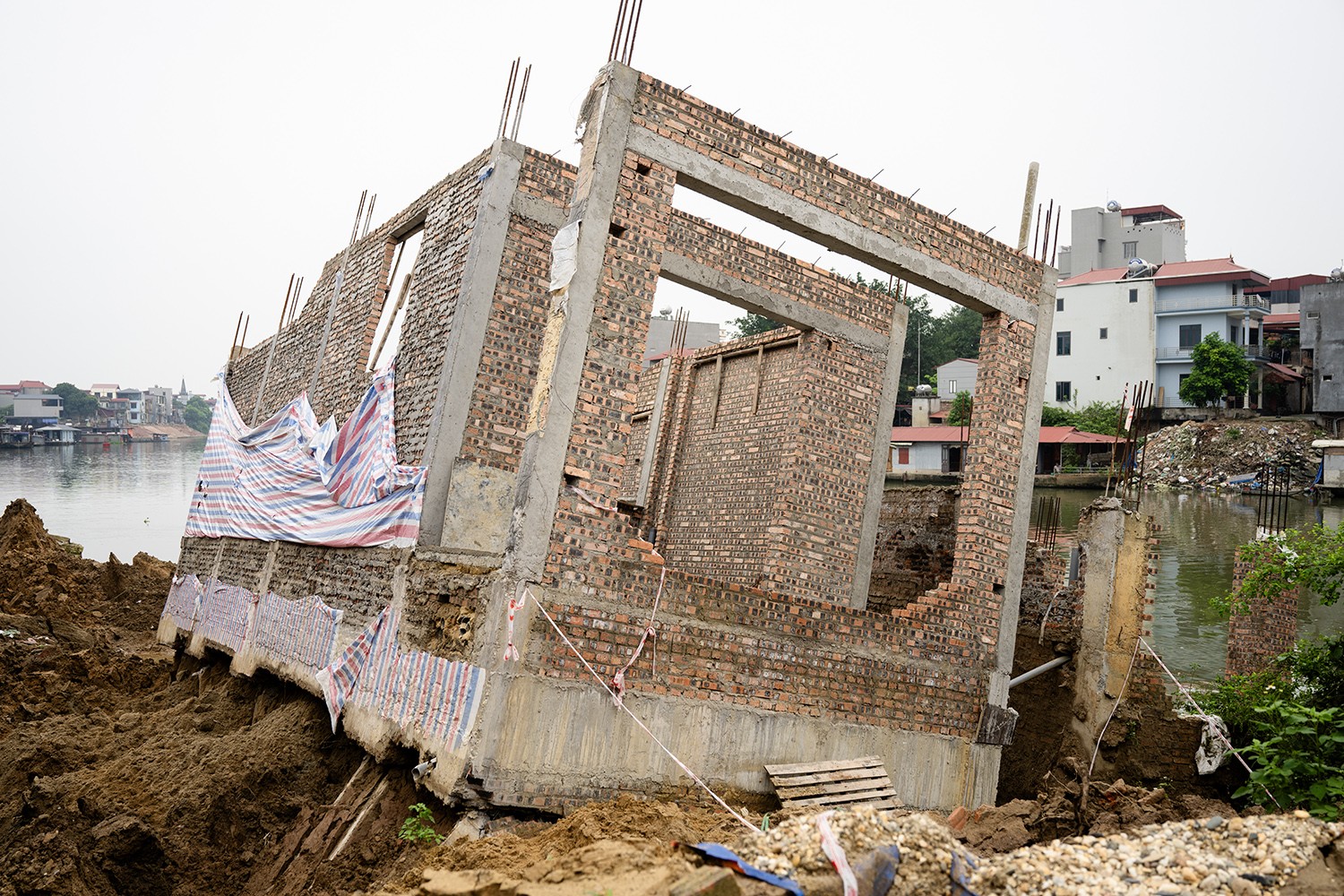 Hai công trình đang xây dựng cũng bị sạt lở xuống sông Cầu.