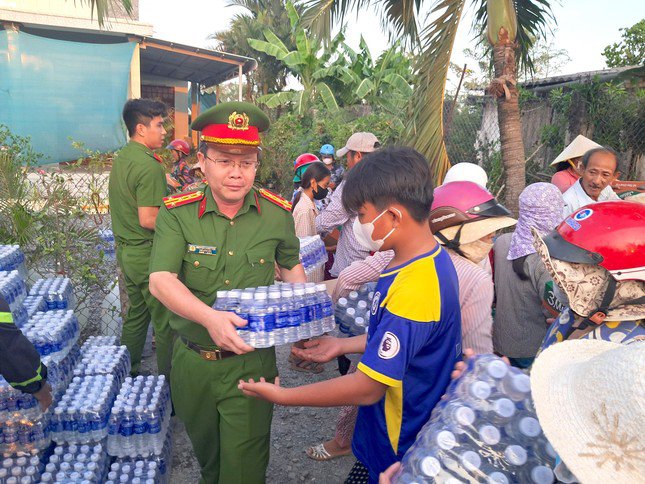 Đại tá Nguyễn Minh Tân - Phó Giám đốc Công an tỉnh tham gia chương trình tặng nước uống cho người dân tại xã Kiểng Phước, huyện Gò Công Đông (Ảnh: Lê Hoài).