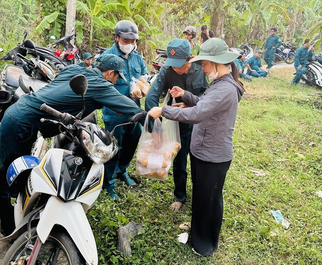 Chị em phụ nữ huyện Trần Văn Thời mang thức ăn, nước uống hỗ trợ lực lượng đang tham gia chữa cháy.