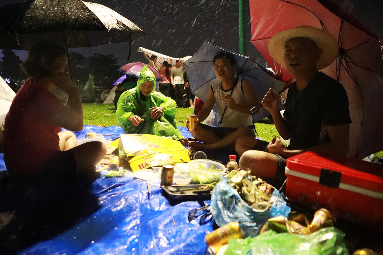 Một nhóm du khách vẫn thoải mái liên hoan bất chấp trời mưa, họ cho biết đang ăn uống thì&nbsp;trời đổ mưa, một số người trong nhóm tìm chỗ trú còn mấy người cầm ô vẫn ngồi liên hoan. Dù bị ướt&nbsp;nhưng đối với họ đây&nbsp;là một kỉ niệm đáng nhớ về Giỗ Tổ Hùng Vương.