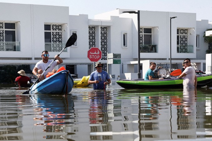 Dân Dubai chèo thuyền chuyển đồ đạc tại một khu nhà liền kề, ngày 18/2. Ảnh: Reuters