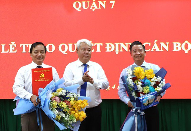 Bí thư Quận ủy quận 7 Võ Khắc Thái trao quyết định cho hai cán bộ lãnh đạo quận. Ảnh: SGGP