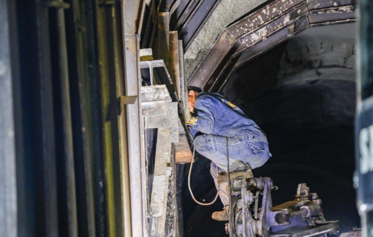 Bên trong hầm, các công nhân hàn nối những trụ thép cuối cùng gia cố mái hầm.