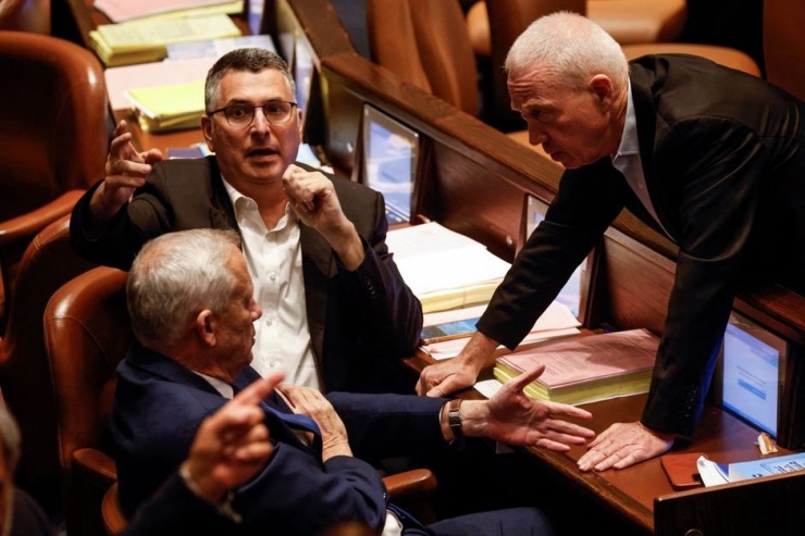 Ông Gantz (ngồi, bên trái) nói chuyện với ông Gallant (đứng) trong cuộc họp quốc hội Israel hồi tháng 7-2023. Ảnh: REUTERS