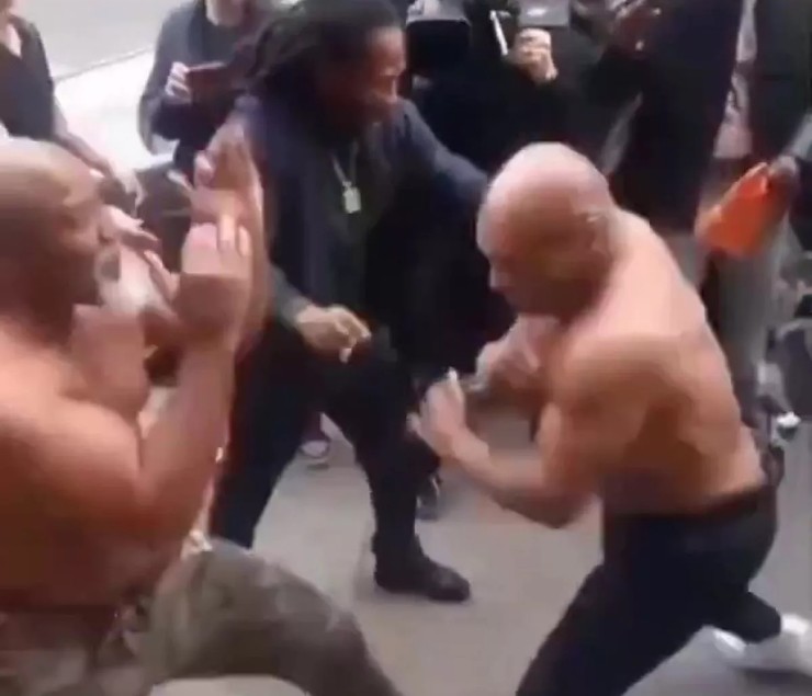 Mike Tyson (right) shirtless, rushes into a fight with Briggs (left) on the streets of New York