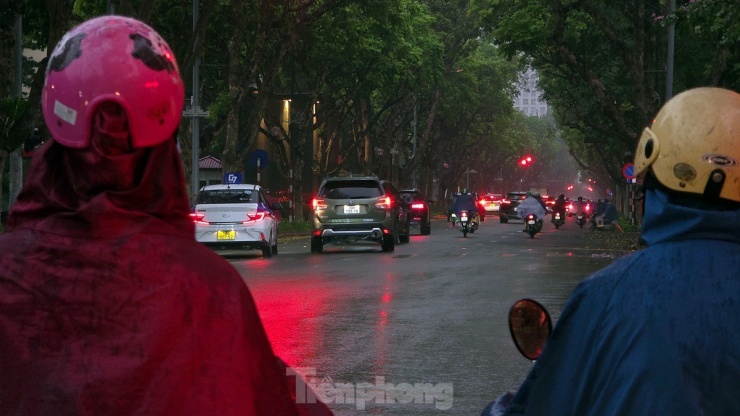 Cơn dông kèm mưa nhỏ khiến đường phố Hà Nội tối đen, giao thông đúng thời điểm đi làm của người dân bị ảnh hưởng.