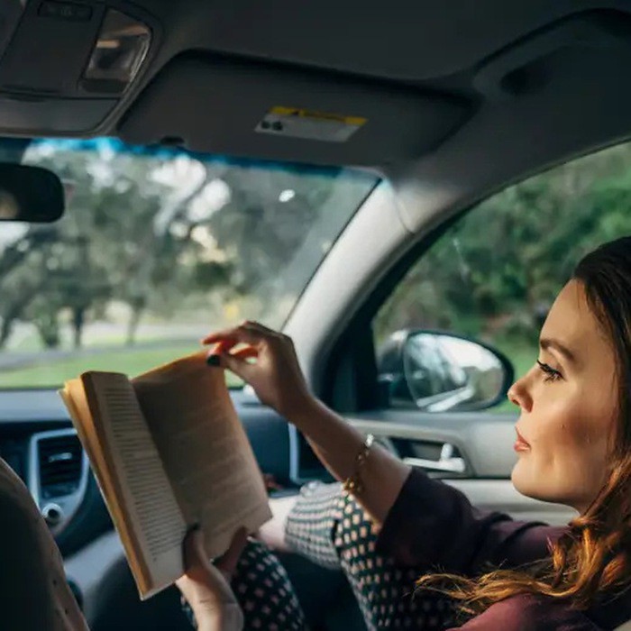 Đọc sách trên xe dễ khiến bạn bị say xe. Ảnh minh họa