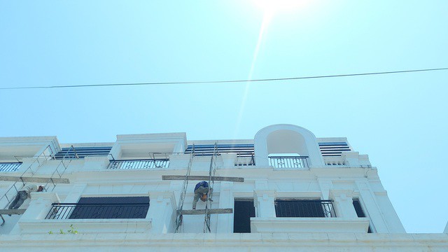 Mặt trời rọi trực tiếp xuống các công nhân sơn sửa nhà cửa tại TP Đông Hà