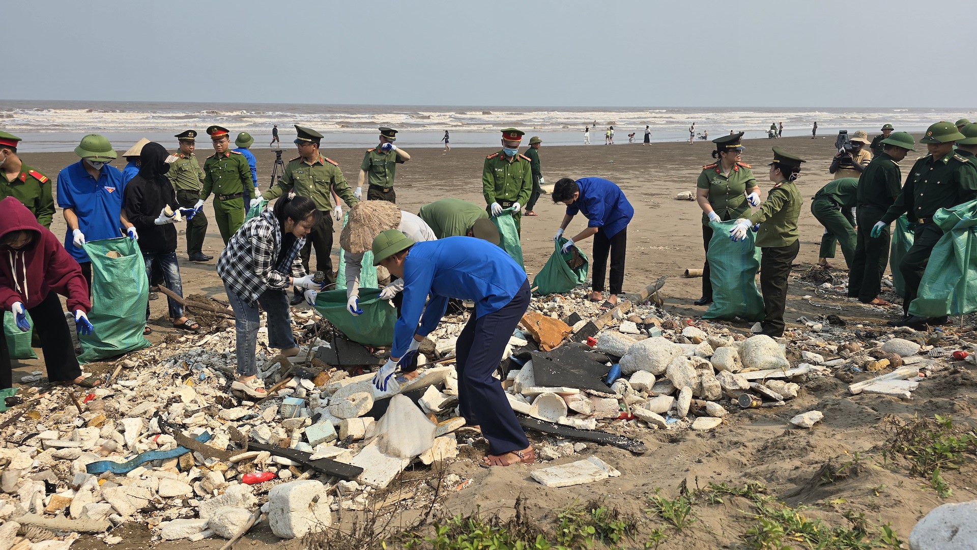Lực lượng chức năng ra quân dọn dẹp rác quanh bãi biển.