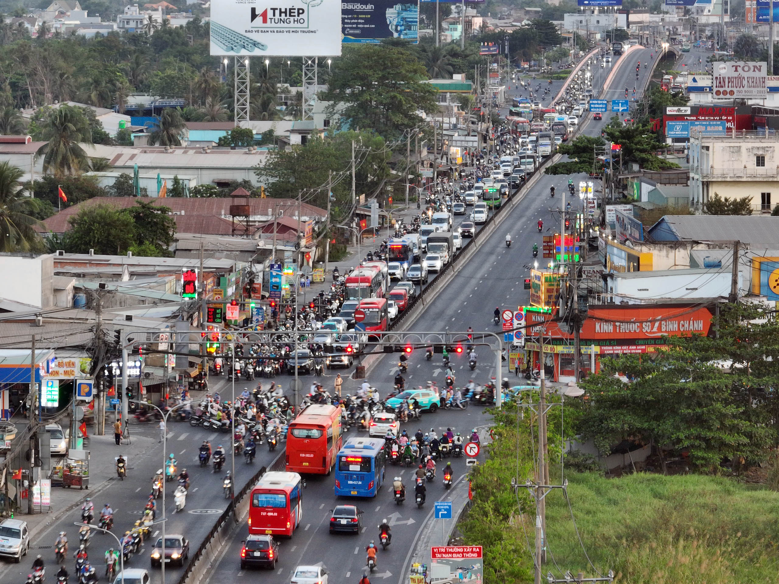 Hơn 18h, tuyến Quốc lộ 1 (huyện Bình Chánh) lượng phương tiện bắt đầu đông nhưng chỉ ùn ứ nhẹ tại các giao lộ dừng đèn tín hiệu.