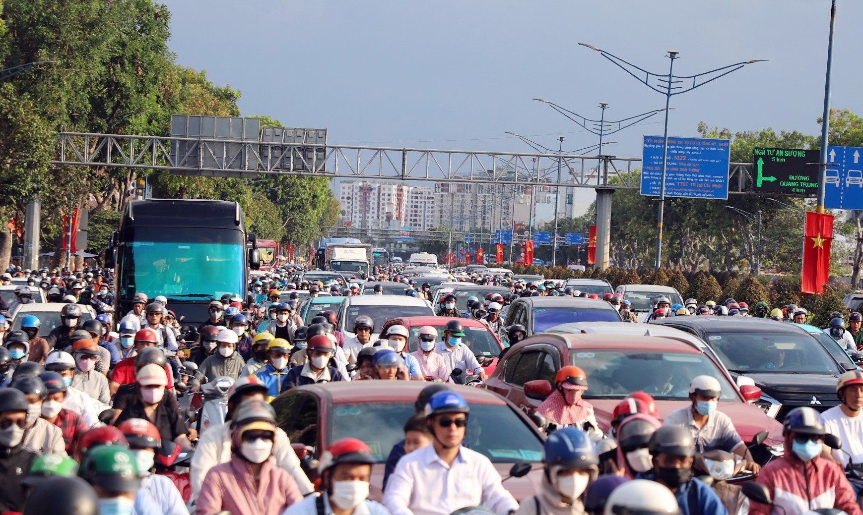 Người dân chen chúc nhau di chuyển trên đường Trường Chinh, xe máy chen vào các khoảng trống giữa các ô tô nhưng vẫn không thoát kẹt xe