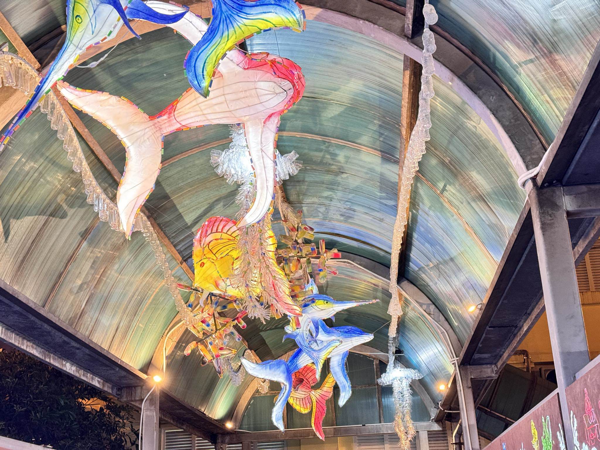 Với chủ đề Nước, hình tượng các loài cá, mực, sứa... trang trí trên mái cầu được làm từ chai nhựa tái chế do học sinh các trường tiểu học trên địa bàn quận thu gom. Tận dụng ánh sáng từ đèn cao áp chiếu hắt xuống tấm che của cây cầu, những tác phẩm hiện lên như một 