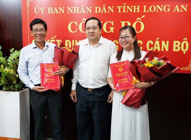 Phó Chủ tịch UBND tỉnh Long An Nguyễn Minh Lâm (đứng giữa) trao quyết định cho ông Hồ Văn Dân và bà Đặng Thị Thanh Huyền. Ảnh: Báo Long An