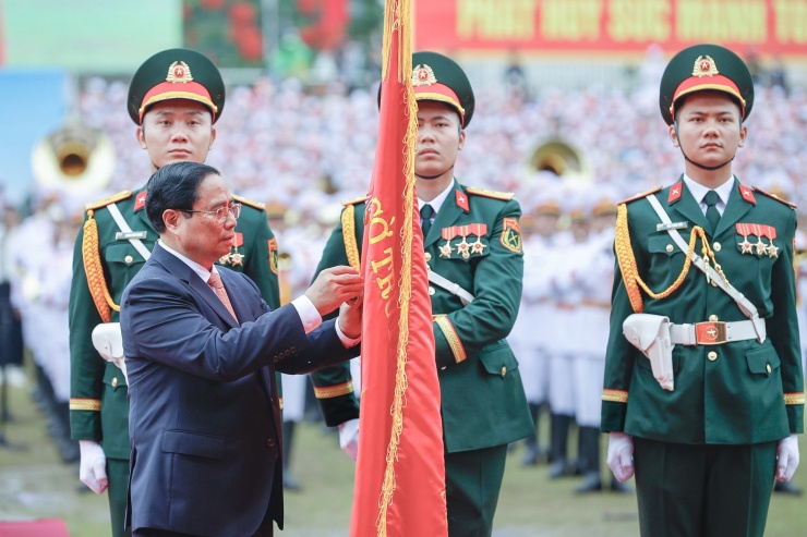 Thủ tướng Chính phủ Phạm Minh Chính thay mặt lãnh đạo Đảng, Nhà nước gắn Huân chương Độc lập hạng Nhất lên lá cờ truyền thống của Đảng bộ, chính quyền và Nhân dân các dân tộc tỉnh Điện Biên. (Ảnh: Như Ý)