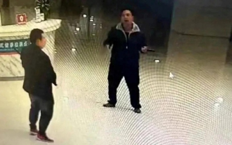 Đối tượng tấn công chĩa dao vào một người đàn ông đang cầm gậy ở sảnh bệnh viện. Ảnh: Red Star News