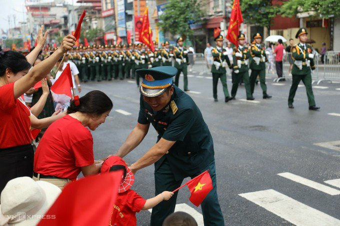 Người dân bên đường bắt tay đội hậu cần phục vụ diễu binh diễu hành. Ảnh:&nbsp;Phạm Chiểu