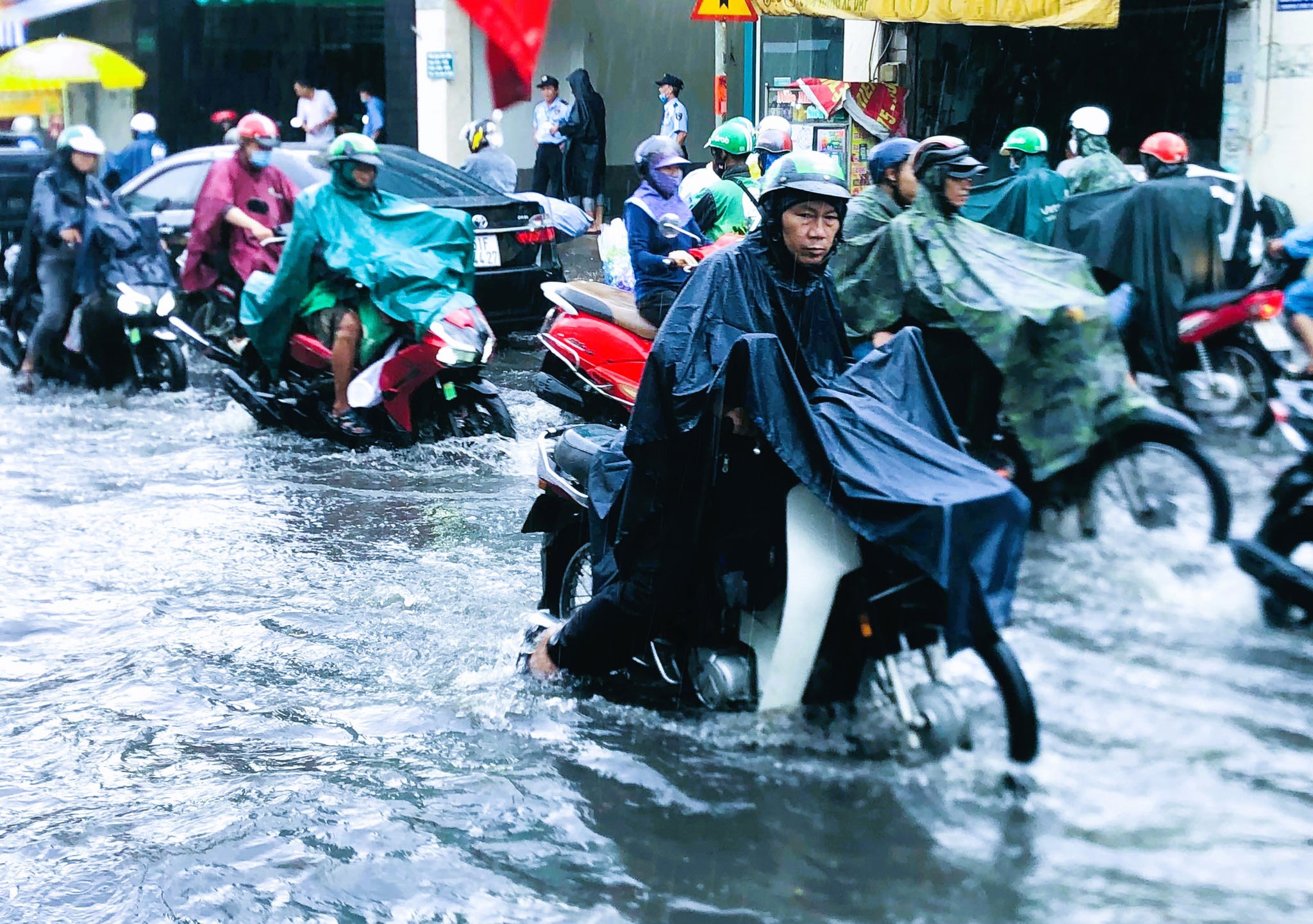 Nhiều phương tiện 2 bánh bị chết máy, người dân ì ạch đẩy bộ khi đi qua đoạn ngập trên đường Lê Văn Việt. Đường ngập cũng khiến giao thông bị ùn tắc nghiêm trọng do các phương tiện chạy chậm hoặc dừng lại chờ nước rút mới dám đi qua.