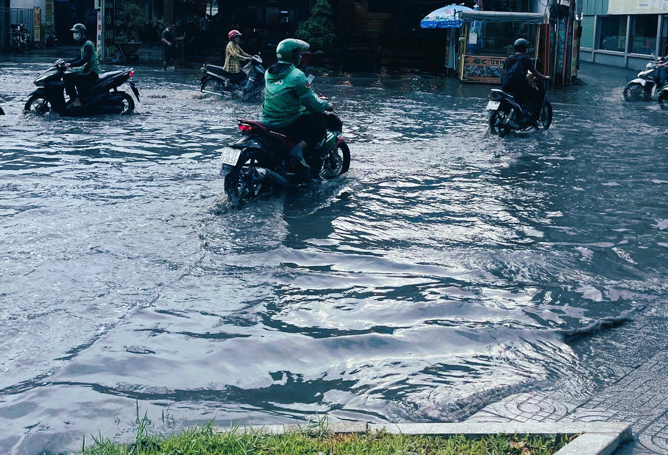 Đường ngập, nước đen ngòm, bốc mùi hôi thối khiến người dân mệt mỏi khi di chuyển vào giờ tan tầm. “Nhìn nước đen ngòm, cuồn cuộn trên đường mà sợ thật. Tôi phải nhắc con trai co chân lên để chân không chạm nước bẩn khi đi qua đoạn ngập”, chị Lê Thị Tư (ngụ TP Thủ Đức) chia sẻ.