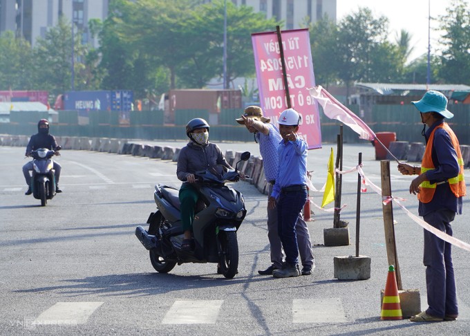 Một phụ nữ lúng túng hỏi đường đi do chưa quen lộ trình mới, sáng 11/5. Ảnh: Gia Minh