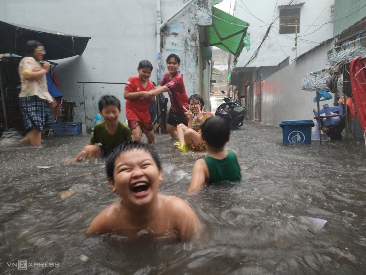 Mưa lớn đầu mùa khiến nhiều trẻ em trên đường Chu Văn An, quận Bình Thạnh thích thú tắm, giải nhiệt sau chuỗi ngày nắng nóng gay gắt.