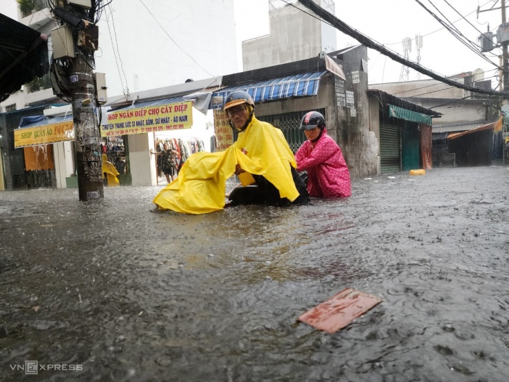 Đường Chu Văn An, quận Bình Thạnh ngập tới quá bánh xe trong cơn mưa kéo dài hơn một giờ. Hàng loạt xe chết máy phải bì bõm, lội nước để tìm nơi sửa.