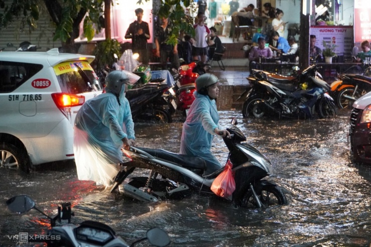 Trong cơn mưa lớn, giao thông rối loạn, hàng loạt xe chết máy trên đường Quốc Hương.